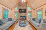 Main Level Living Room Features Ample Seating, Large Screen TV, and Gas Fireplace